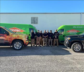 Men standing in front of SERVPRO trucks